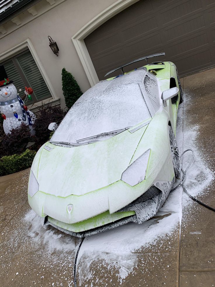 Luxury black Porsche covered in foam during premium detailing